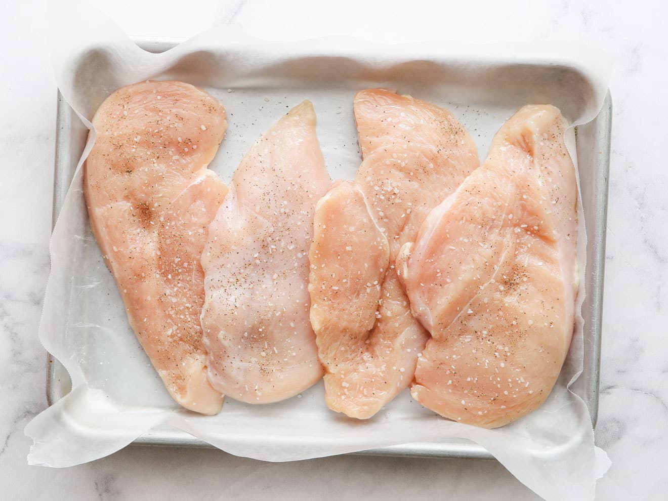 sliced chicken breasts with salt and pepper