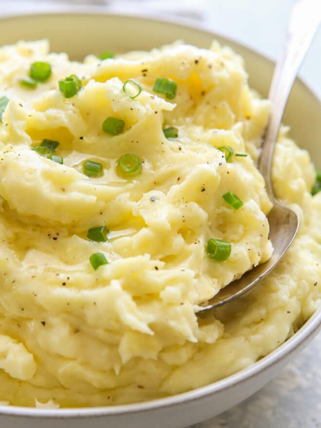 close up of mashed potatoes in bowl with scallions