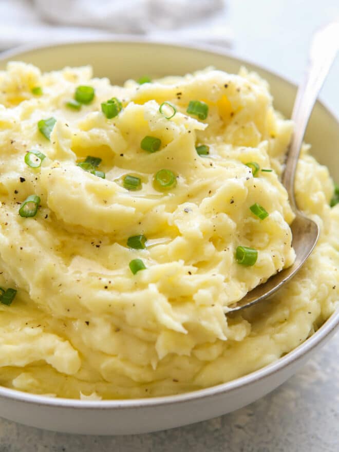 close up mashed potatoes in bowl with scallions