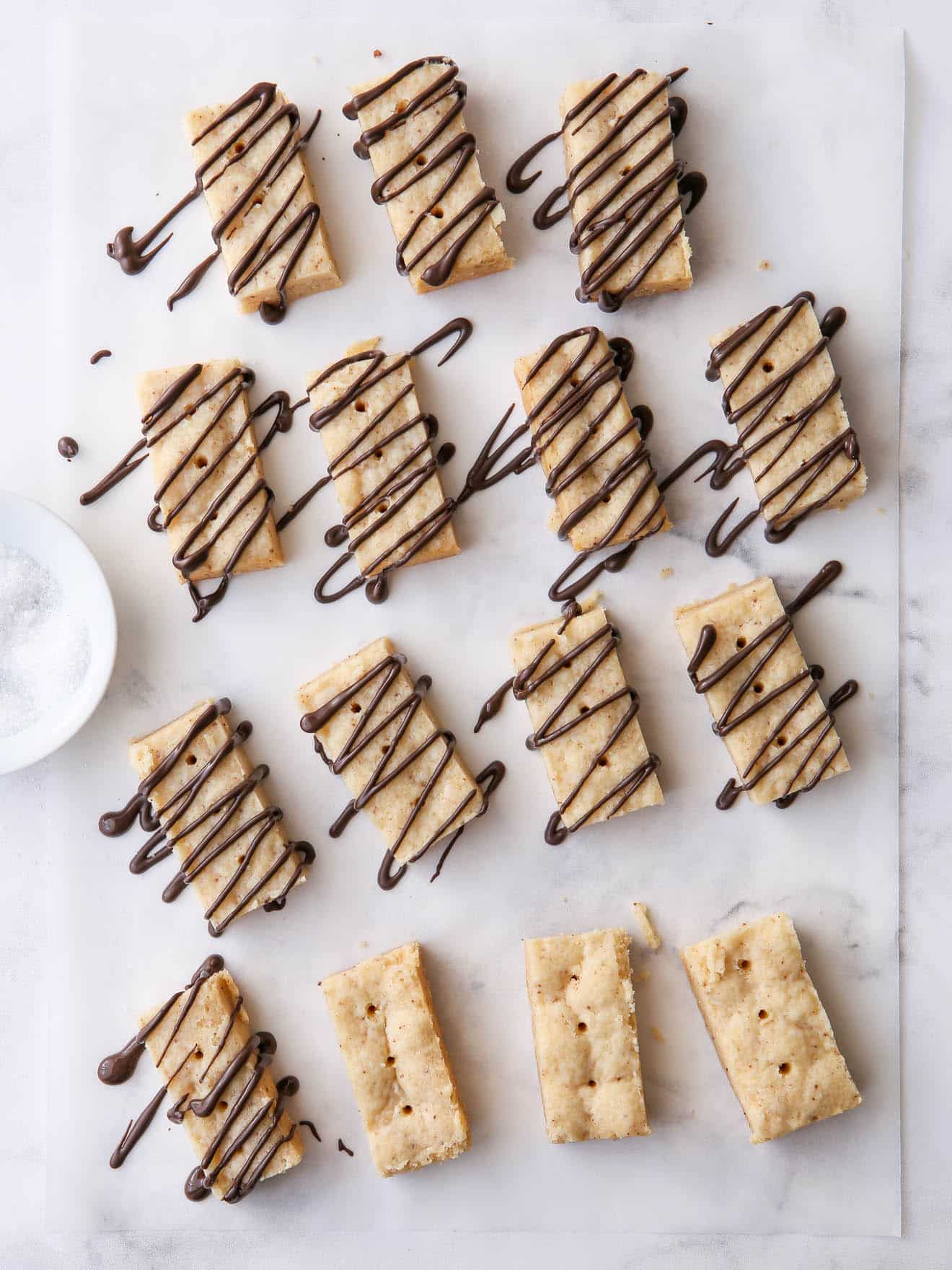 brown butter shortbread cookies on parchment with chocolate drizzle
