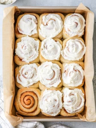 frosted no-knead cinnamon rolls in a pan