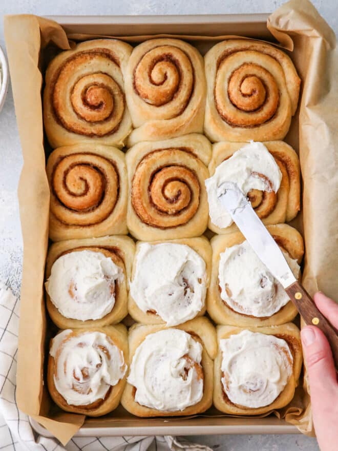 frosting the baked cinnamon rolls