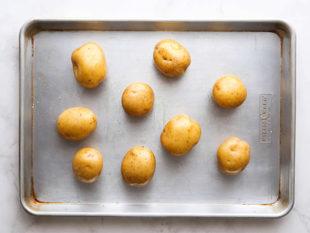 potatoes on a sheet pan ready for roasting