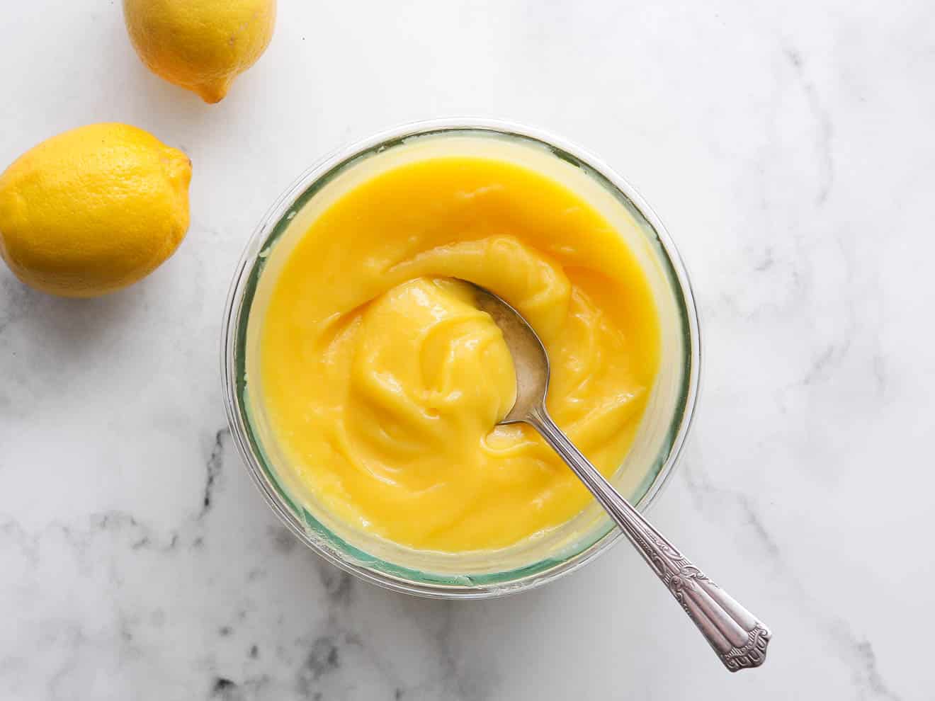 bowl of luscious lemon curd with a spoon in it