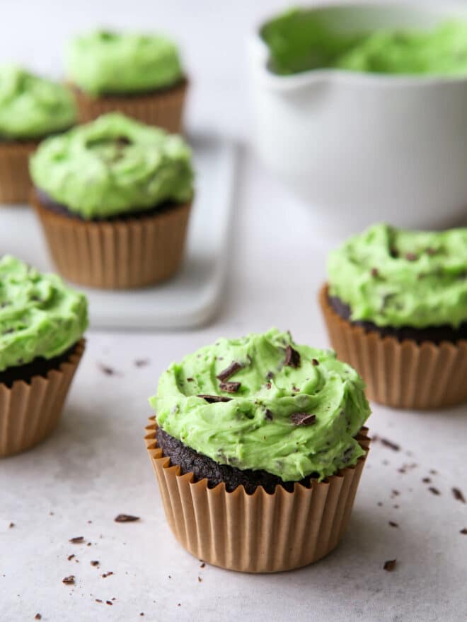 closeup of mint chocolate chip cupcake with others in the background
