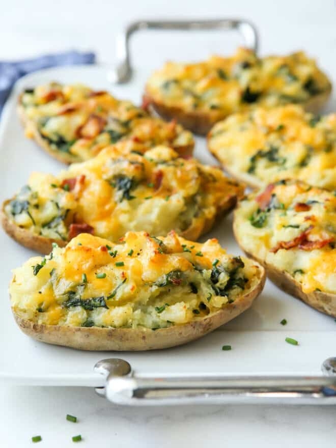 focus on one spinach and cheddar twice-baked potato on a platter