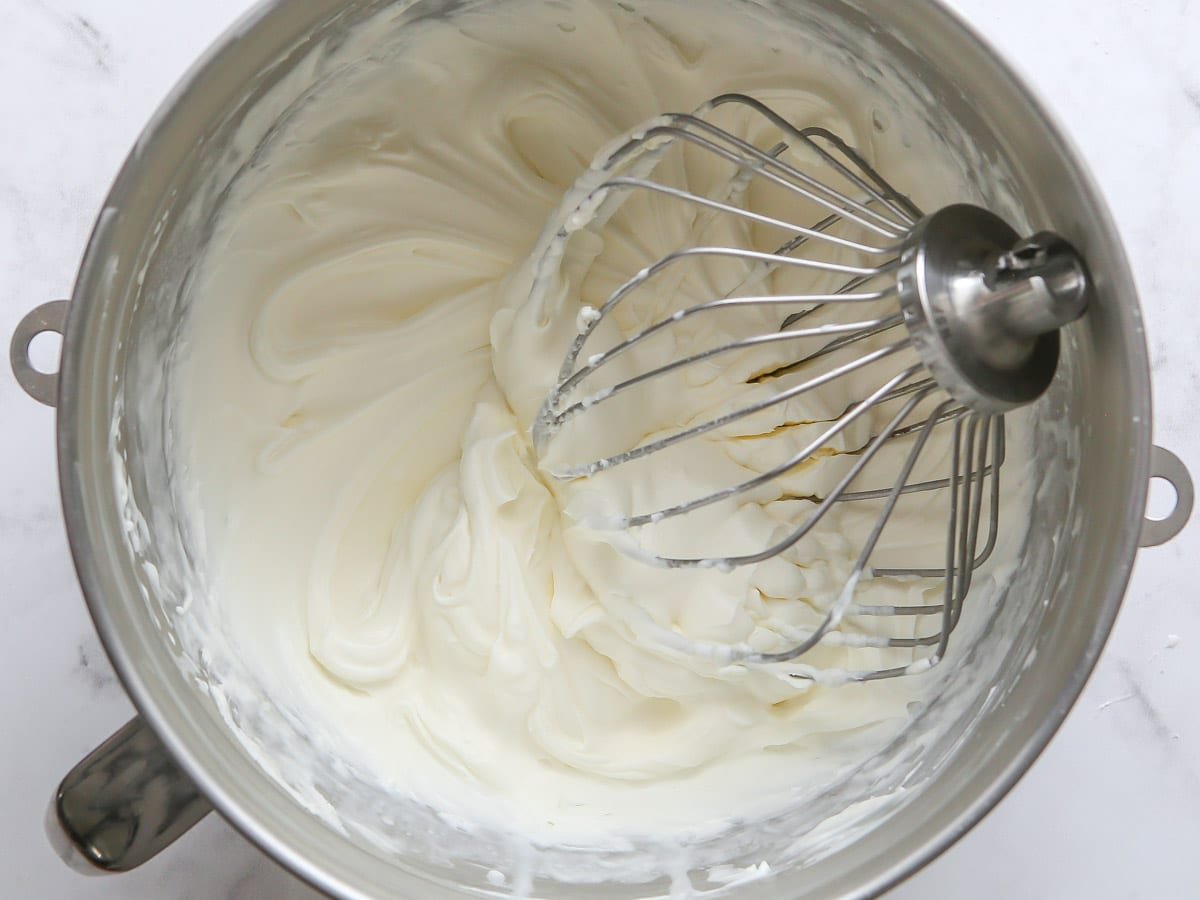 whipped chantilly cream frosting in bowl with whisk attachment