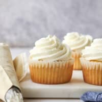 piping chantilly cream frosting onto cupcakes