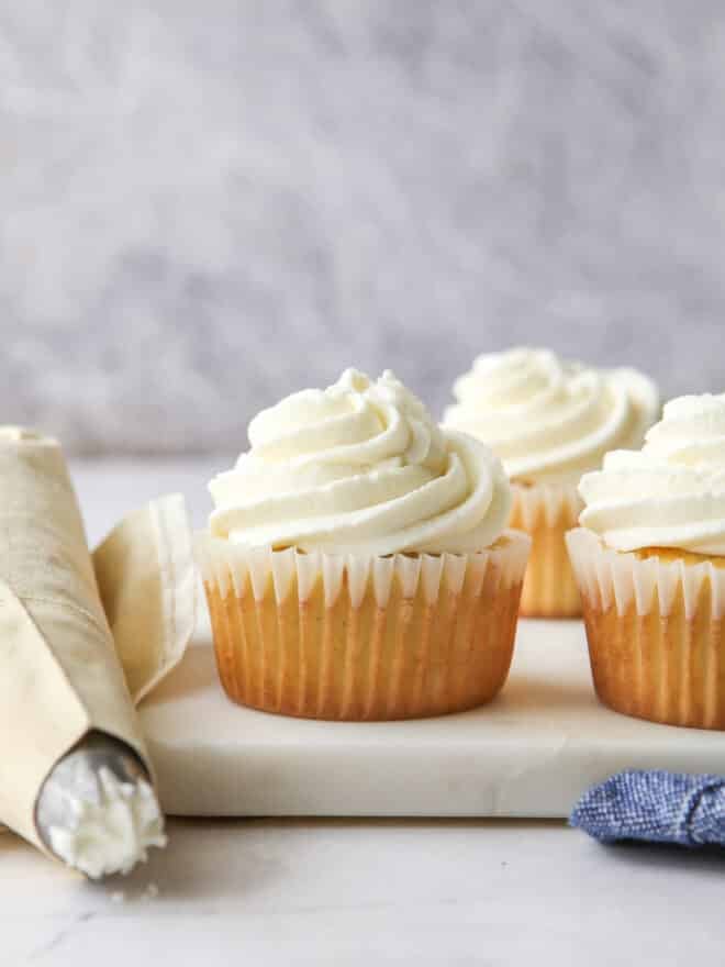 piping chantilly cream frosting onto cupcakes