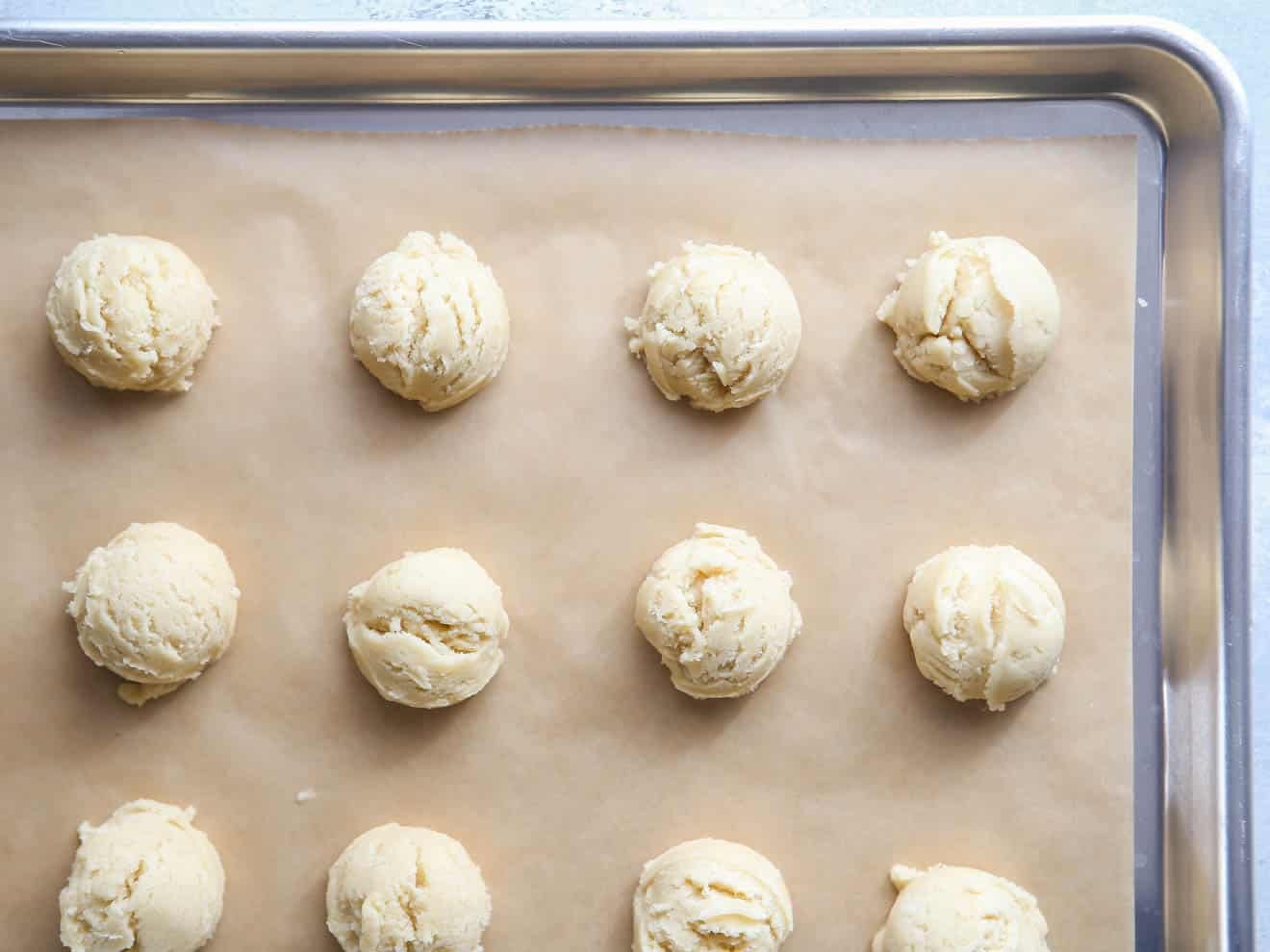 scooped sugar cookie dough on a sheet pan