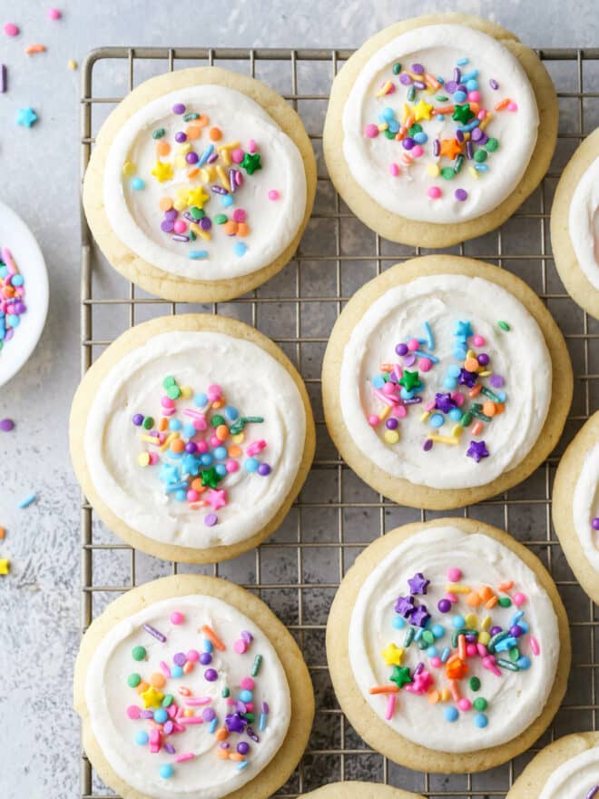 frosted sugar cookies with sprinkles on a wire rack