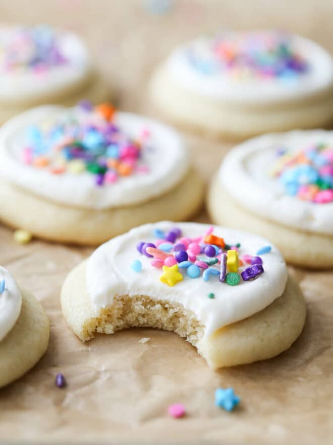 close up of a frosted sugar cookie with a bite taken out of it