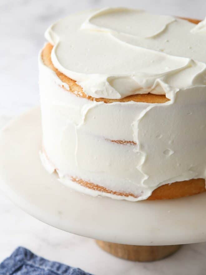 spreading chantilly cream frosting on a cake