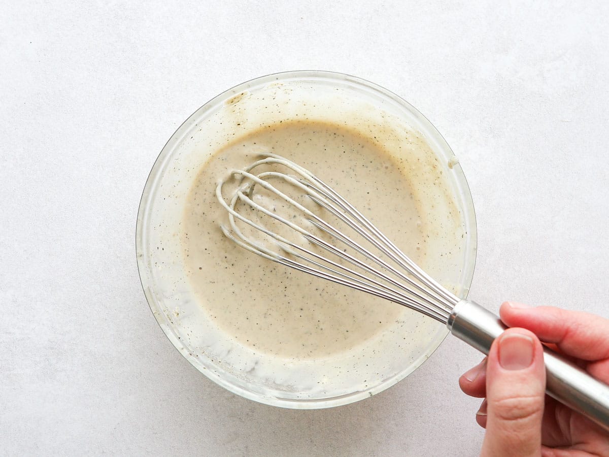 whisking homemade dressing in a bowl