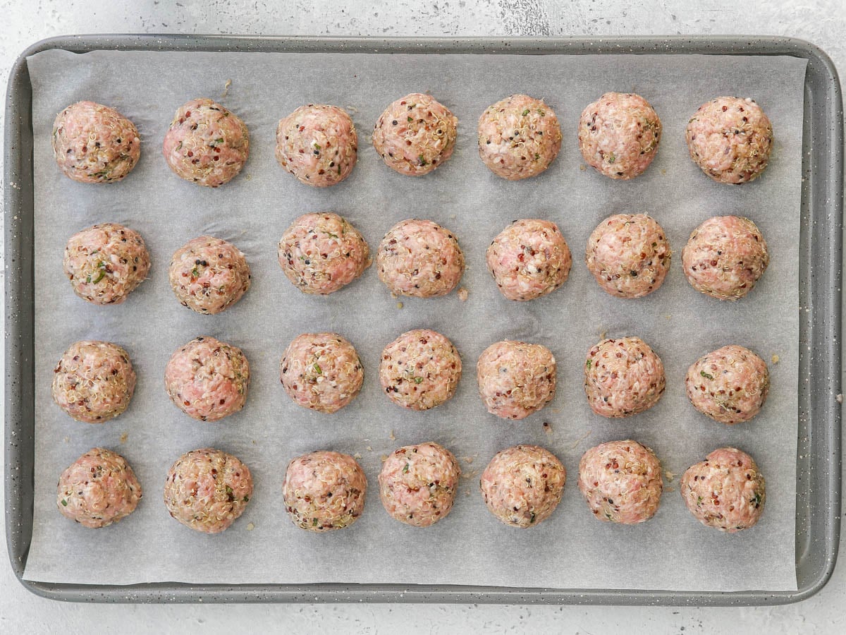 scooped and rolled meatballs on a sheet pan