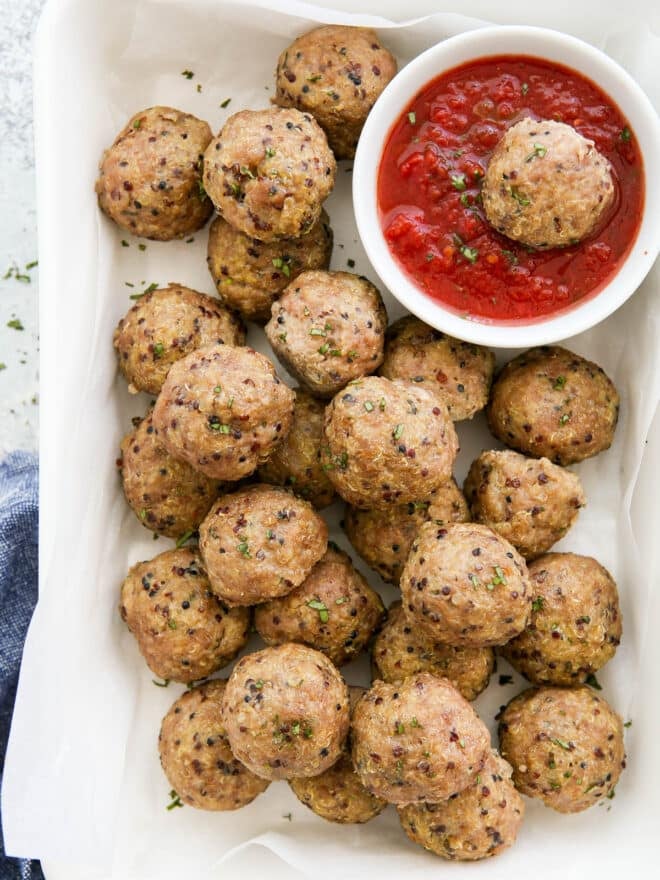 pork quinoa meatballs with a bowl of marinara sauce