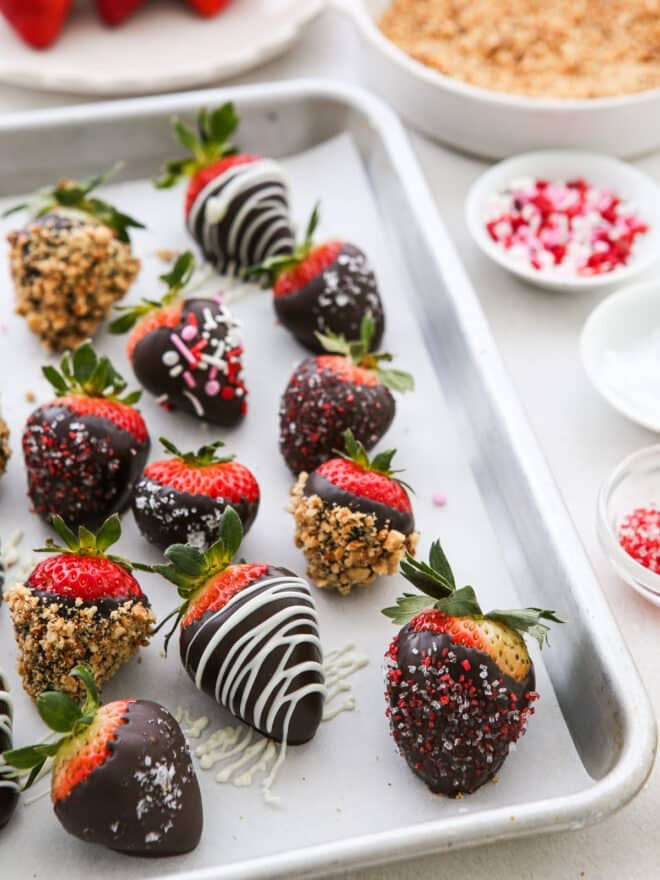 decorated chocolate covered strawberries on a sheet pan