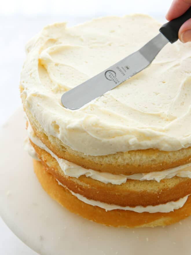 frosting vanilla cake layers and assembling cake