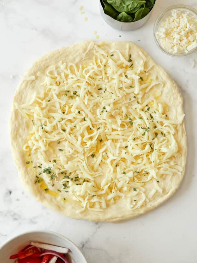 preparing a white pizza with all the toppings