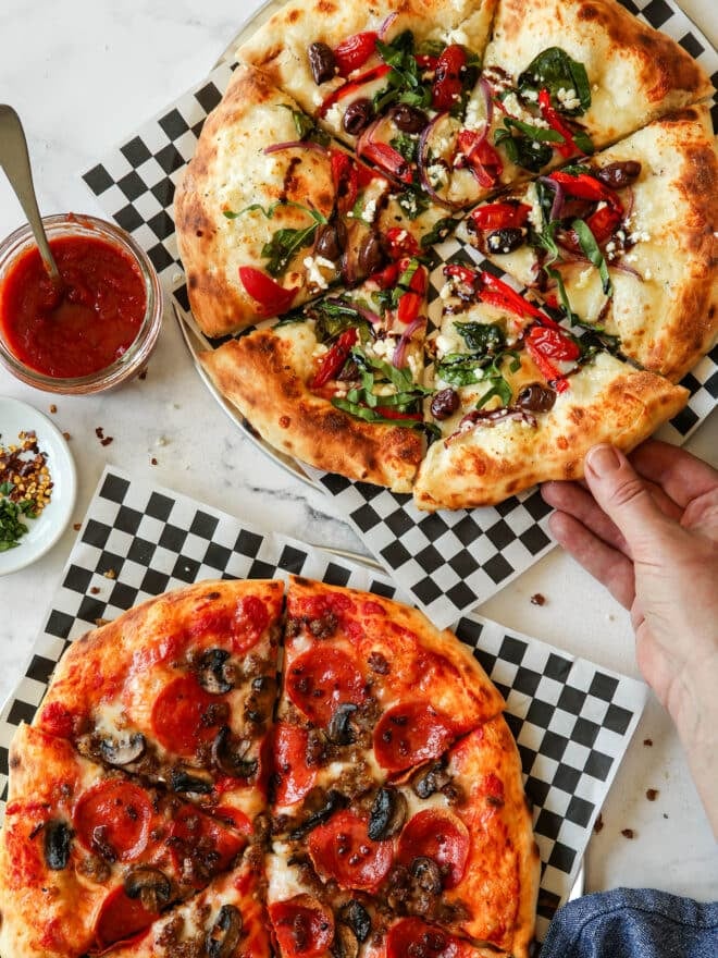 hand grabbing a piece of pizza