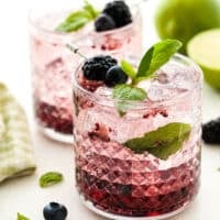 close up of berry basil gin and tonic cocktails in glasses with ice