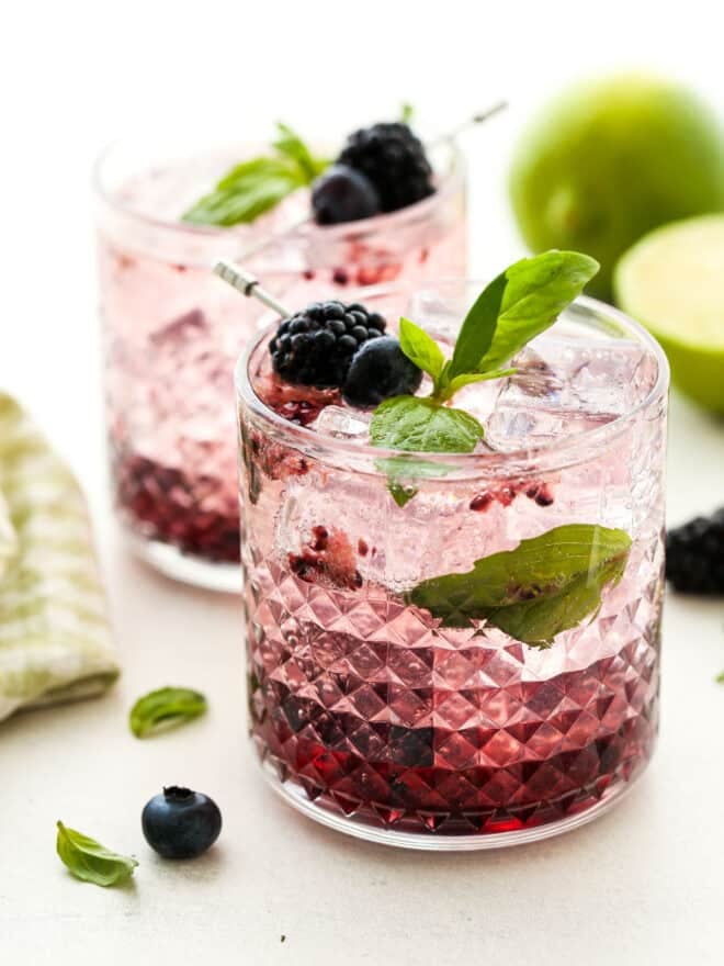 close up of berry basil gin and tonic cocktails in glasses with ice