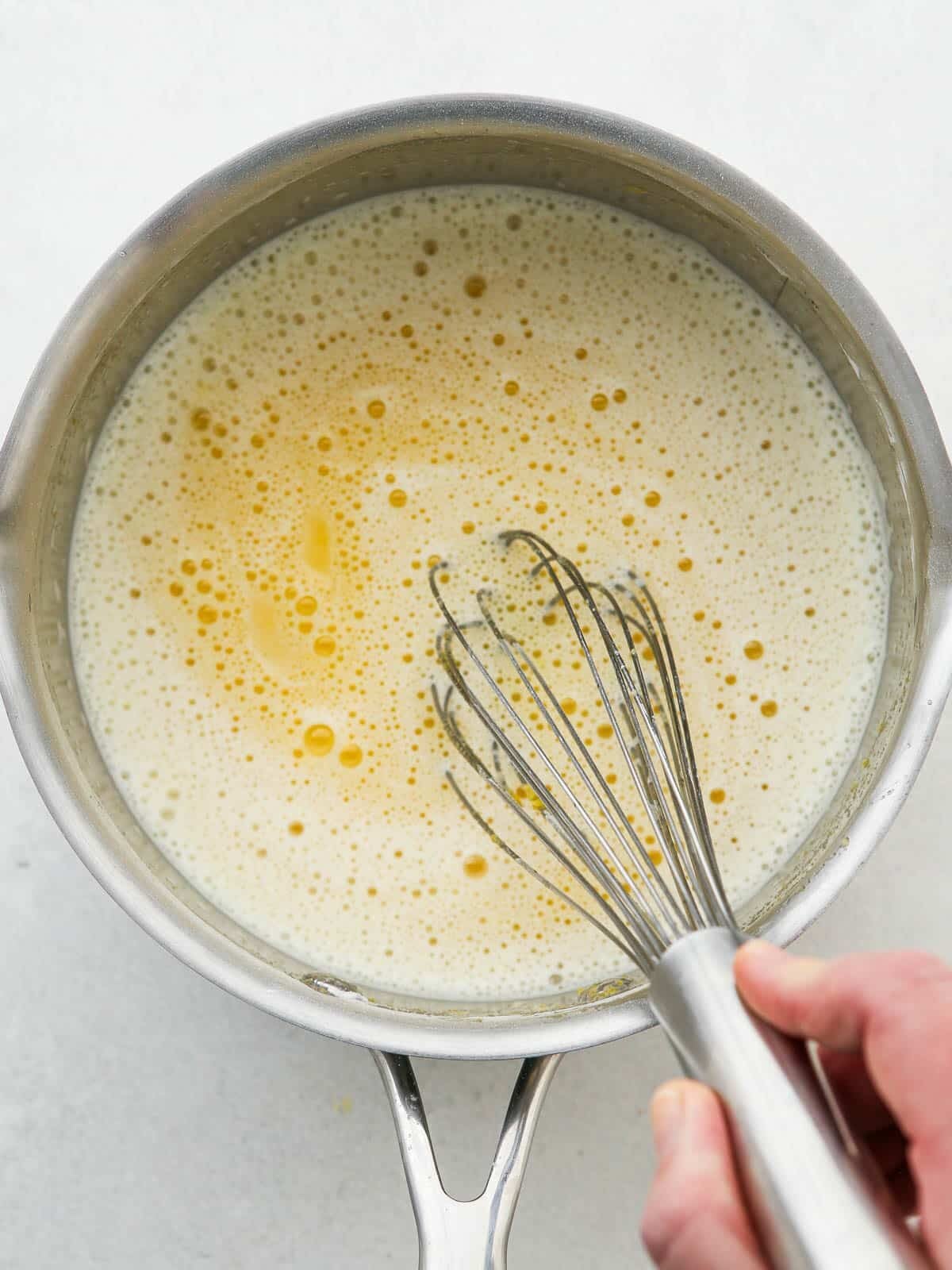 whisking egg mixture in saucepan to start the lemon pie filling