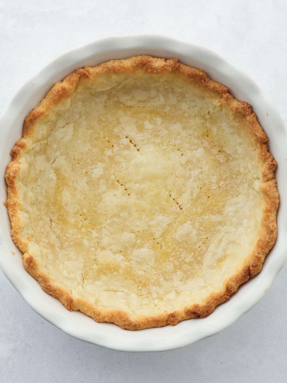 blind baked pie crust in white ceramic pie dish