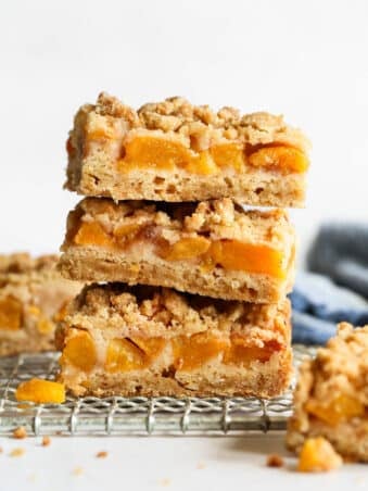 stacked slices of peach crumb bars so you can see all of the layers